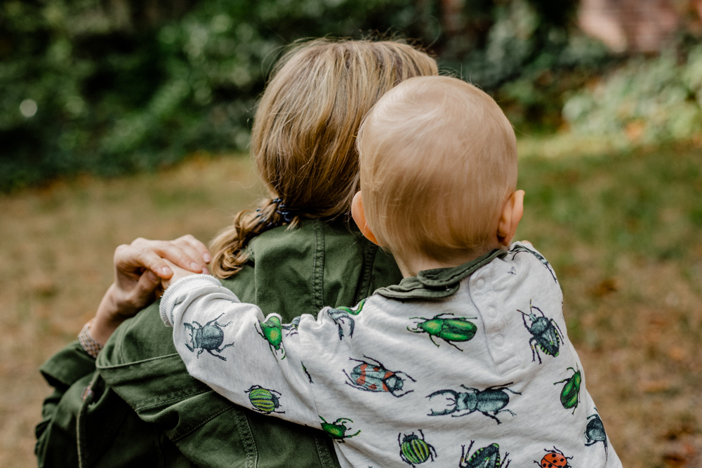 Erwachsene und Kleinkind umarmen einander