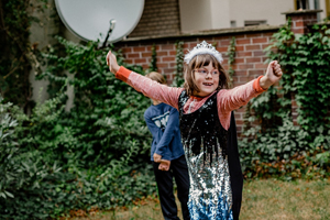 Kind hebt begeistert die Arme in die Höhe